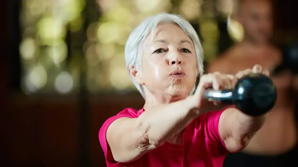 Older woman doing weight training Greenock  to help her strength and longevity 