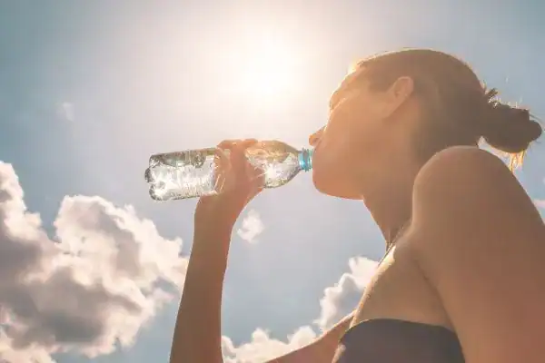 Hydration: The Secret Ingredient for a Toned Stomach and Enhanced Fitness 3 Image of woman drinking water to hydrate Greenock after run.